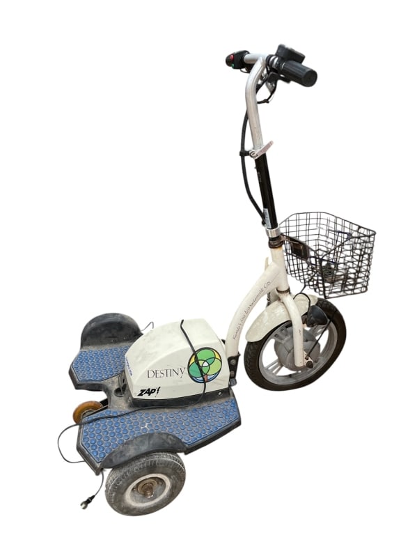 ZAP DESTINY ELECTRIC MOBILITY SCOOTER WITH BASKET: Compact and practical ZAP “Destiny” electric mobility scooter featuring a three-wheel design, upright handlebars with hand controls, and a front wire basket for convenient storage. This eco-fr