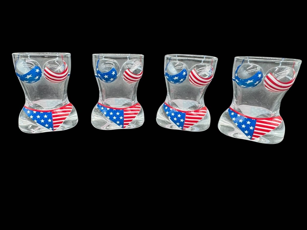 4 PATRIOTIC GLASS SHOT GLASSES: Four clear glass shot glasses shaped like torsos with American flag-themed bikini designs. Shipping Available at www.DeJaVuAuctionShipping.com By bidding in this auction you agree that you have read T