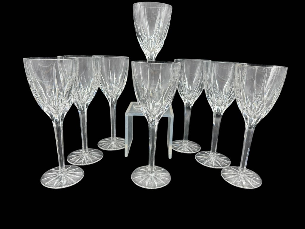 8 CUT CRYSTAL WINE GLASSES: 8 cut crystal wine glasses, each measuring approximately 7.25 inches tall. Features a decorative star pattern on the base. Shipping Available at www.DeJaVuAuctionShipping.com. By bidding in this aucti