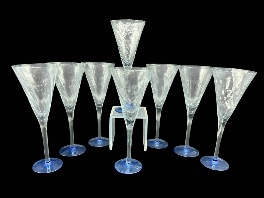 9 BLUE STEM ETCHED CHAMPAGNE GLASSES: Nine champagne glasses featuring etched clear bowls and blue glass stems. Each glass measures approximately 8 inches in height. Shipping Available at www.DeJaVuAuctionShipping.com. By bidding in this 