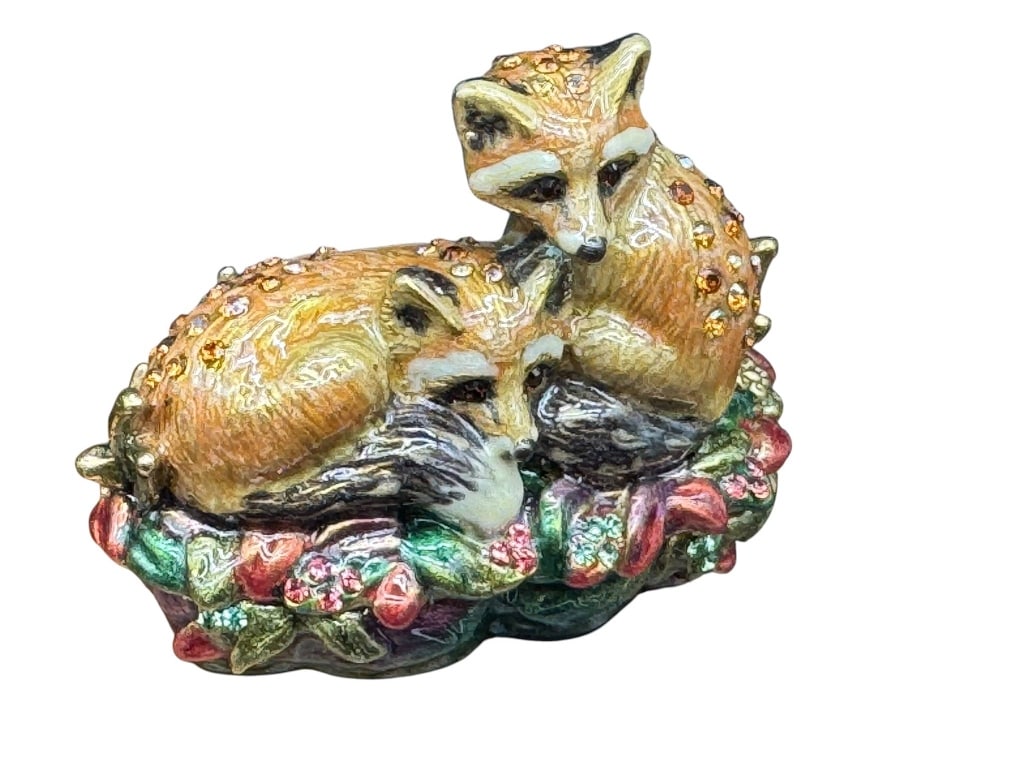 JAY STRONGWATER ENAMEL FOX FIGURINE BOX: Jay Strongwater enameled decorative box featuring two foxes resting on a floral base. Includes original packaging and style information. Shipping Available at www.DeJaVuAuctionShipping.com By bidding 