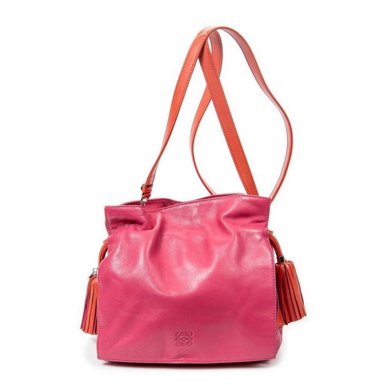 LOEWE PINK AND ORANGE LEATHER SHOULDER BAG: This Loewe shoulder bag features vibrant pink leather with contrasting orange leather straps and tassel details. The interior is lined with a patterned fabric and offers spacious storage. Stylish and 