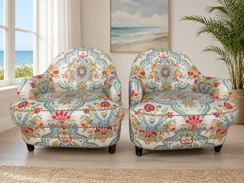 PAIR FLORAL UPHOLSTERED CLUB CHAIRS 38": Elegant pair of upholstered club chairs featuring a richly patterned floral and botanical fabric in soft blue, cream, red, coral, green, and gold tones. Each chair has a rounded barrel-style back, rol