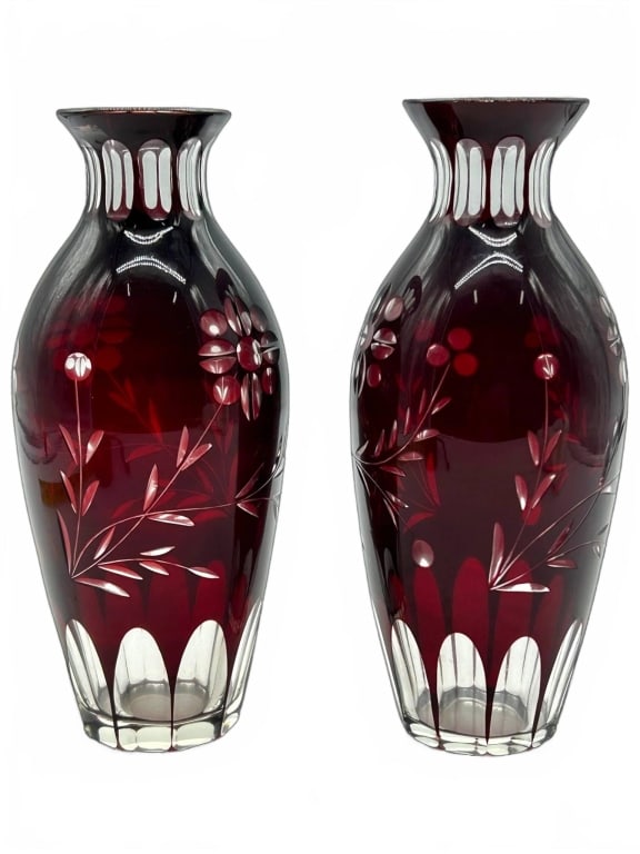 PAIR RUBY RED CUT TO CLEAR GLASS FLORAL VASES 9": Ruby cut to clear glass vases featuring floral and botanical motifs. Each vase measures approximately 9 inches in height and about 2 inches in diameter at the base. Elegant decorative pieces for any s