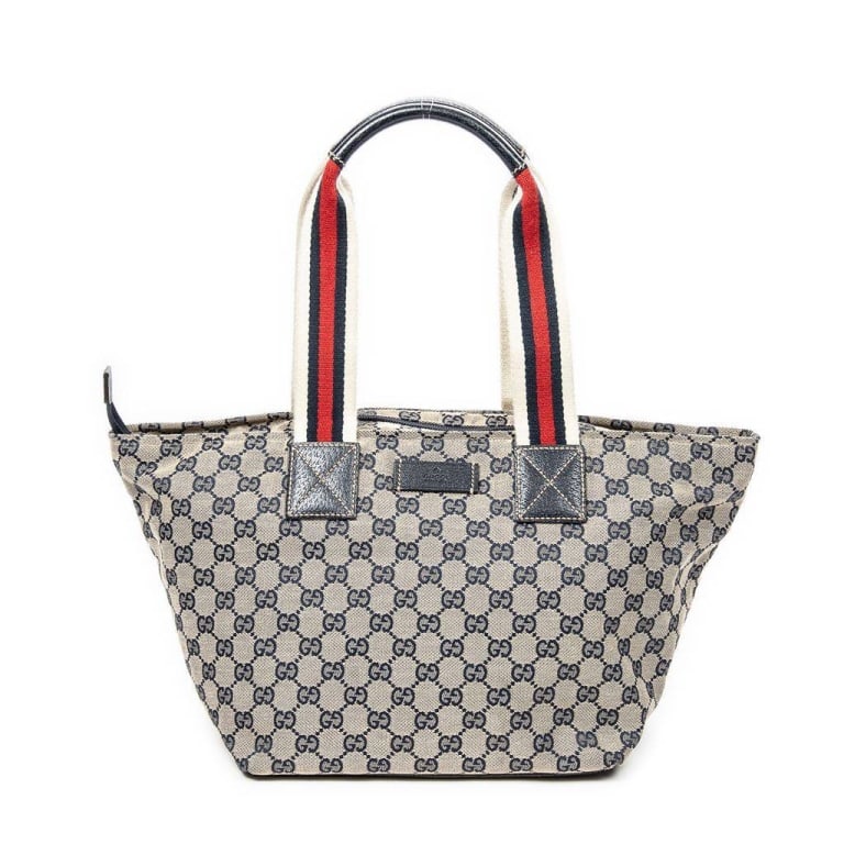 GUCCI GG SUPREME CANVAS TOTE BAG: Gucci GG Supreme canvas tote bag with blue monogram pattern, blue leather accents, and signature red-and-blue webbed handles. Features a spacious interior with zip pocket. Made in Italy. Classic and s