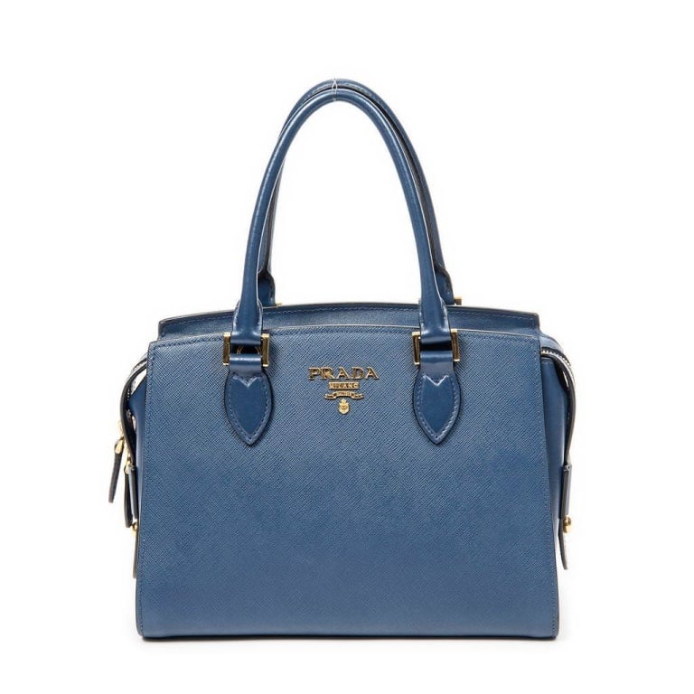 PRADA BLUE SAFFIANO LUX TOTE HANDBAG: This elegant Prada handbag features blue Saffiano Lux leather, dual rolled top handles, gold-tone hardware, and a spacious fabric-lined interior. The bag includes zip side compartments and signature P
