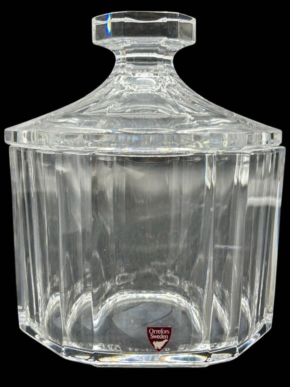 ORREFORS SWEDEN CRYSTAL LIDDED JAR 8": Crystal lidded jar made by Orrefors, Sweden. Features an octagonal shape with faceted sides and a matching crystal lid. Signed and labeled at the base. Measures approximately 8"H and 6" in diameter.
