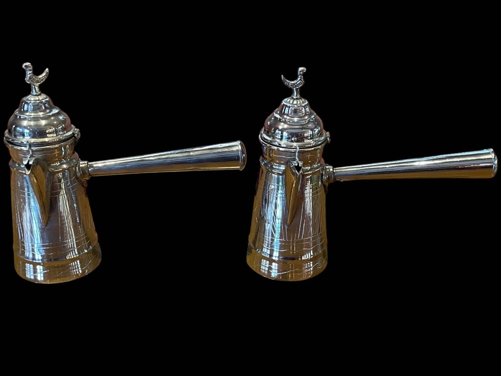 2 SILVER TONE ENGRAVED MOROCCAN COFFEE POTS 9": Vintage hand-engraved brass Maroccan coffee pots with long side handles and domed lids, each finial topped with crescent moon. Measuring approximately 9" tall and 9" long. Both vessels feature traditi