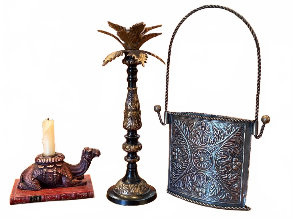 3 PCS DECORATIVE CANDLEHOLDER LOT 14": Three decorative candleholders: a camel on a book with candle, a tall metal holder with ornate leaves, and a square embossed metal holder with handle. Heights range up to approximately 14 inches. Some