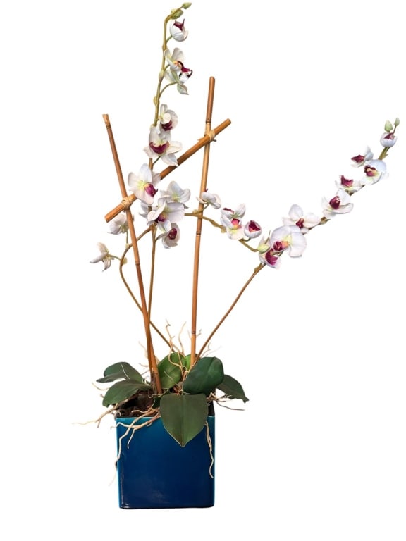 ARTIFICIAL ORCHID IN BLUE SQUARE PLANTER: Artificial white and magenta orchid floral arrangement displayed in a modern blue square ceramic planter. Supported by natural bamboo stakes. Suitable for home or office decor. Carefully crafted for a