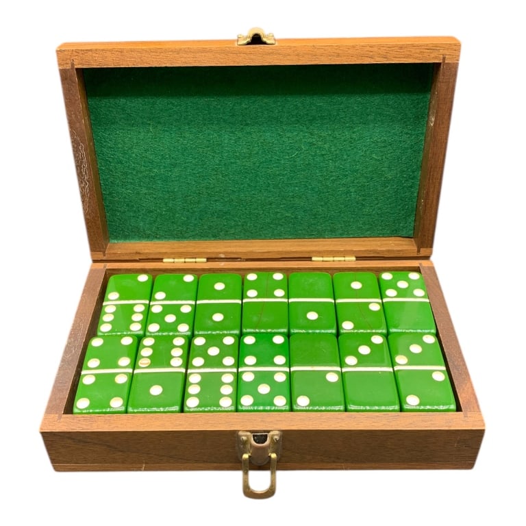 GREEN VINTAGE DOMINO SET IN WOODEN CASE 8": Domino set featuring green tiles with white dots, housed in a hinged wooden case with brass clasp. The interior is lined with green felt. Approximately 8" wide. | | Location -Pit