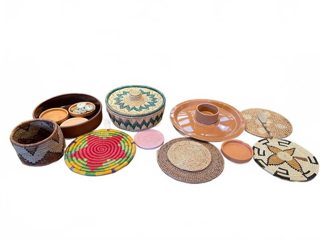 HANDWOVEN BASKETS AND POTTERY LOT: Variety of handwoven baskets in different shapes and colors, alongside several clay pottery pieces, such as trays, small dishes, and a platter. The set highlights traditional craftsmanship and