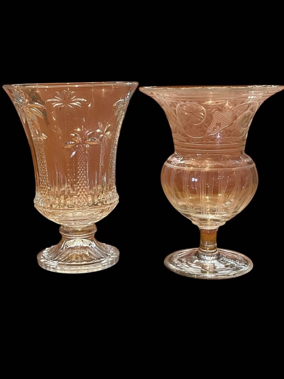 PAIR OF CUT GLASS VASES 8": Decorative cut glass vases, each approximately 8 inches in height. Both feature intricate etched designs with one sporting palm motifs and the other ornate floral scrollwork. Elegant additions for