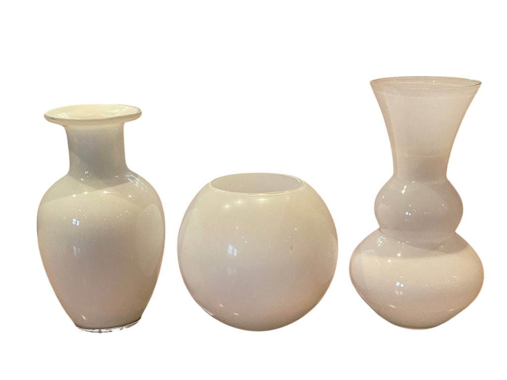 3 MID CENTURY MODERN WHITE GLASS VASES 9": Three white glass vases in varying shapes and styles. The tallest vase measures approximately 9 inches high. Each vase features a smooth, glossy finish, ideal for modern decorative use.