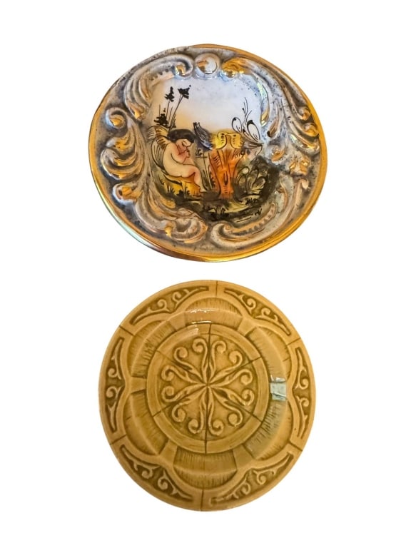 ORNATE COLLECTIBLE DECORATIVE PLATES: Two vintage decorative plates. One plate displays an intricate relief and painted scene, possibly hand-painted, while the other has a detailed embossed pattern. Both plates measure approximately 3inch
