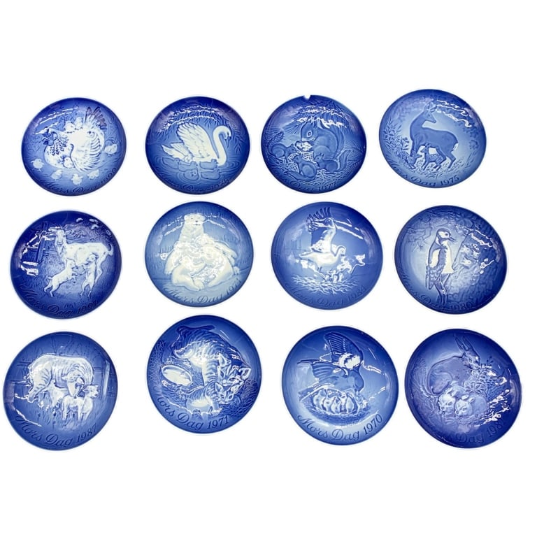 ROYAL COPENHAGEN MOTHER'S DAY PLATES 1970-1991 6": 12 Royal Copenhagen Mother's Day collector plates, sporadic years dated from 1970-1991. Each blue and white porcelain plate measures approximately 6 inches in diameter. Made in Denmark. Features anima