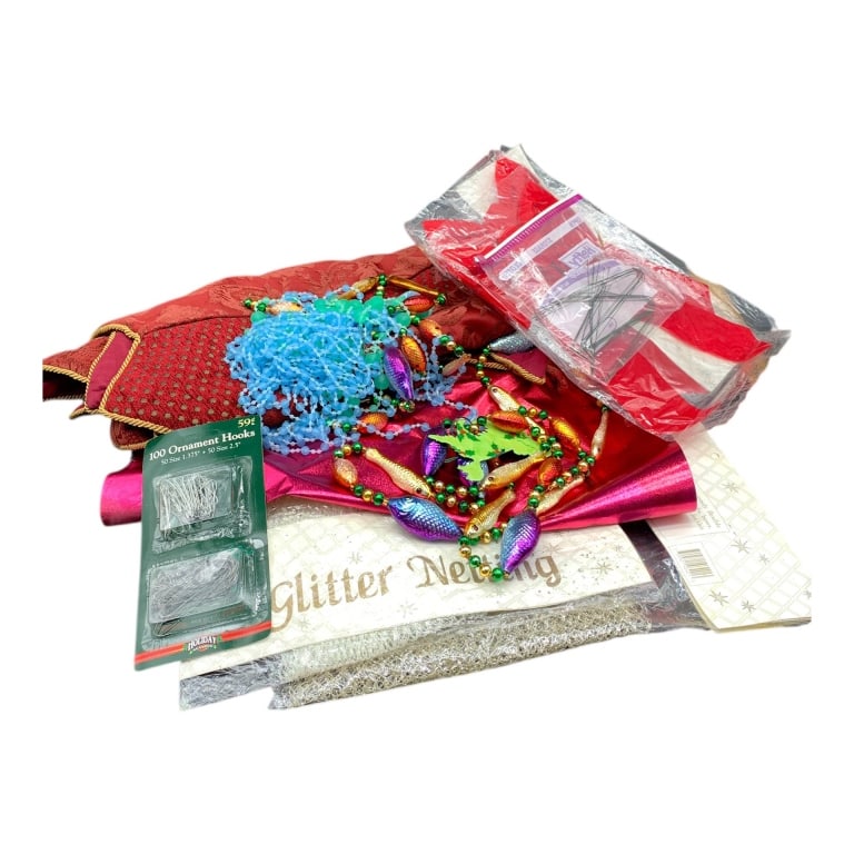 MIXED HOLIDAY LOT DECOR AND SUPPLIES BIN 20": Clear lidded storage bin filled with assorted holiday decor and craft supplies. Contents feature glitter netting, metallic wrapping paper, ornament hooks, colorful bead garlands, and fabric. Great for