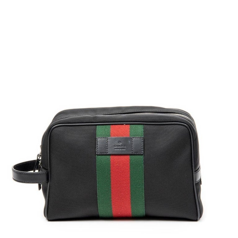 GUCCI BLACK NYLON WEB STRIPE TOILETRY BAG: This Gucci toiletry bag features signature green and red web stripe, crafted in black nylon with leather trim and silver-tone hardware. The interior is spacious and lined, with a leather 'Gucci made i