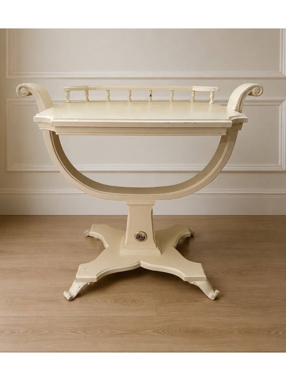 CREAM PAINTED NEOCLASSICAL STYLE TABLE 24": Cream-painted neoclassical style side table featuring scroll arms, gallery rail, and curved pedestal. The base includes a hand-painted oval porcelain medallion depicting a courting couple in 18th-cent