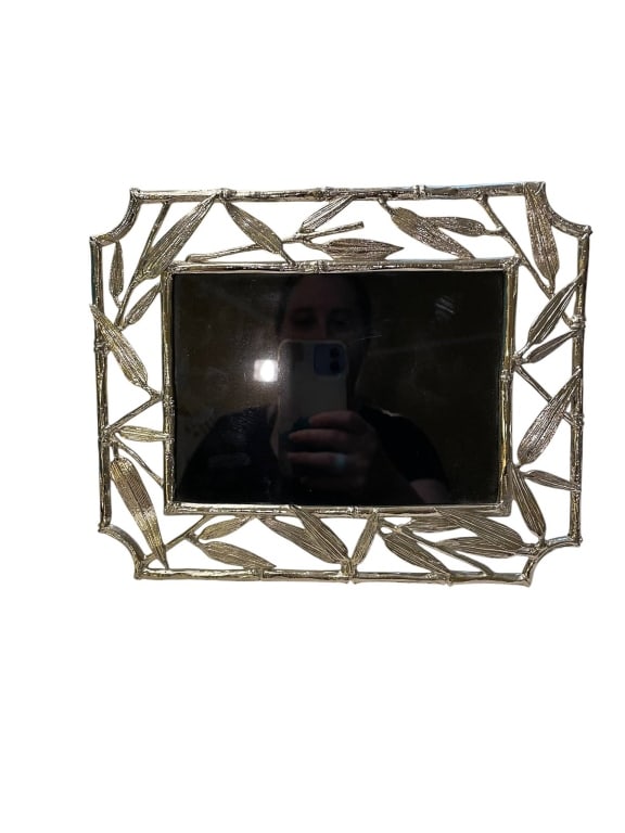 SILVER TONE BAMBOO LEAF MOTIF METAL FRAME 10": Rectangular photo frame with an intricate leaf motif border in silver-tone metal. Suitable for tabletop display. Measures approximately 10 inches wide. Elegant and stylish, ideal for home or office de