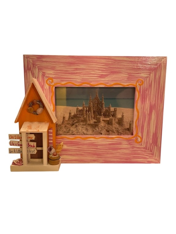 PINK WOOD PICTURE FRAME WITH BEACH HUT DECOR 9.5": Decorative pink wood picture frame featuring a playful beach hut and signs. The frame fits a standard photo, with front measurements of approximately 9.5 inches wide by 7.5 inches tall. Ideal for beac