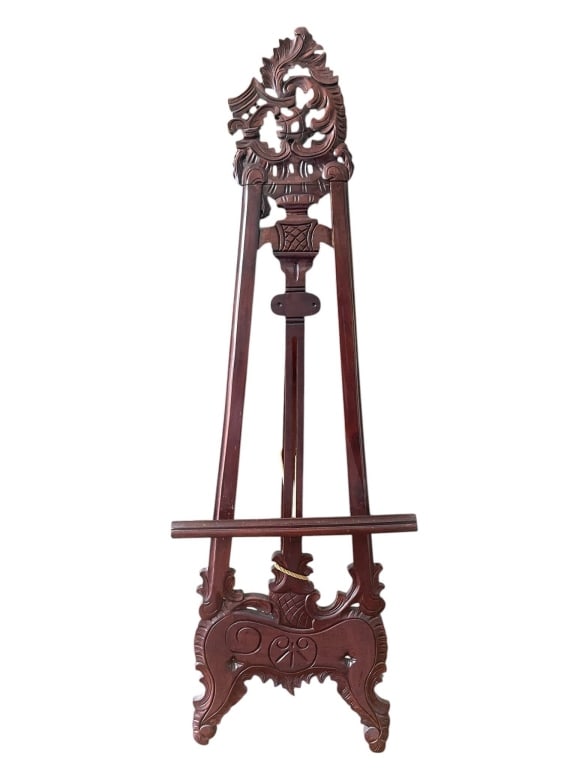 ORNATELY CARVED WOODEN DISPLAY EASEL 63": This is an elegantly hand-carved wooden easel featuring intricate detailing and a rich finish. Suitable for displaying artwork, photographs, or signage, this decorative stand adds a touch of sophistic