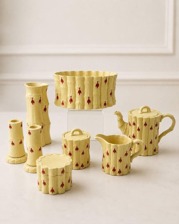 WEDGEWOOD BAMBOO PRIMROSE CERAMIC TEA SET 8": Eight-piece ceramic tea set in natural yellow glaze with bamboo motif and red floral accents. Includes teapot, creamer, covered jar, container, vase, two candlesticks, and oval planter. Measurements s