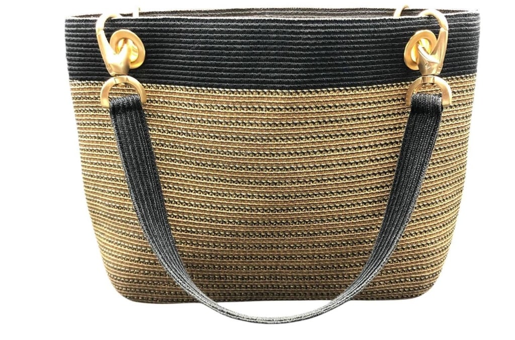 ERIC JAVITS STRAW HANDBAG BLACK AND GOLD 11": This Eric Javits handbag features a black and gold woven straw exterior, gold-tone hardware, and a vibrant yellow interior. The tag reads 'Made in China, Hand Finished in USA.' Stylish and practical, 