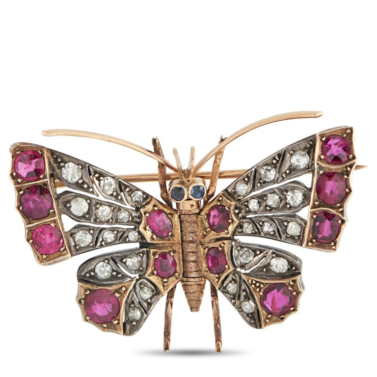 LB EXCLUSIVE ANTIQUE 14K ROSE GOLD AND SILVER 0.80: This antique brooch draws inspiration from nature. Ruby gemstones with a total weight of 3.50 carats and sparkling Diamond accents totaling 0.80 carats add color, texture, and dimension to the butterf