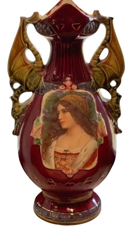 VINTAGE PORCELAIN VASE WITH PORTRAIT DECOR 9": Antique porcelain vase featuring a hand-painted portrait of a woman in Renaissance attire. Burgundy base with ornate dragon-style handles. Measures approximately 9 in tall and 5 in wide. Excellent dis