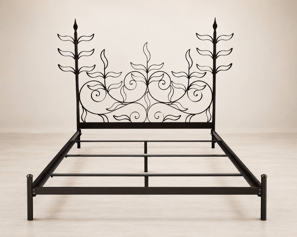 WROUGHT IRON FLORAL SCROLL QUEEN BED FRAME 82": Wrought iron queen-sized bed featuring an ornate, botanical headboard with scroll and leaf details. | | APPROXIMATE DIMENSIONS: 82"L X 78"W X 68"H | | Does NOT Include floral-patterned bedding set. | 