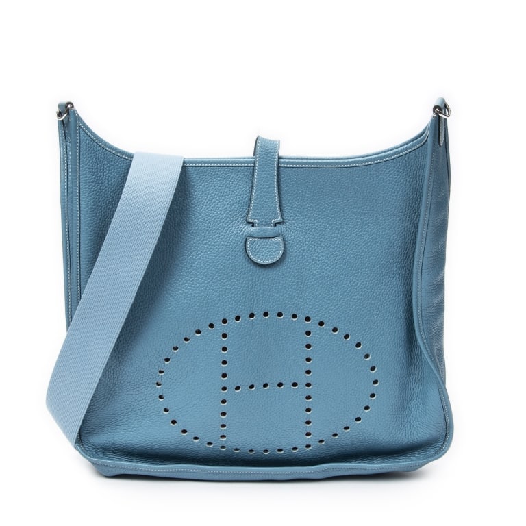 HERMES EVELYNE II TGM BLUE JEAN CLEMENCE BAG: The Hermes Evelyne II TGM is crafted in beautiful Blue Jean Clemence leather and finished with palladium-plated hardware for a timeless yet casual luxury aesthetic. Known for its iconic perforated H d