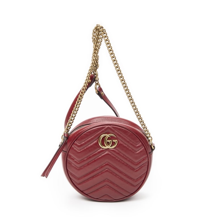 GUCCI GG MARMONT ROUND MINI RED BAG: The Gucci Mini GG Marmont Round Crossbody is crafted in vibrant red quilted chevron leather and accented with signature gold-tone hardware. Featuring the iconic Double G logo and a distinctive round s