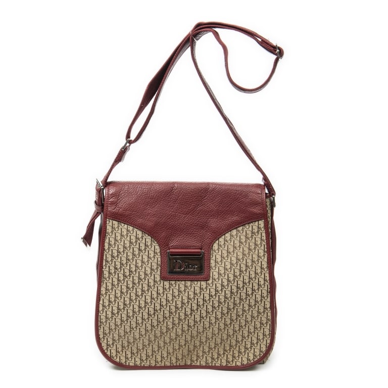 DIOR STREET CHIC FLAP MESSENGER BAG: The Dior Street Chic Flap Messenger Bag showcases a striking red and beige Diorissimo canvas design accented with sleek silver-tone hardware. Combining the relaxed functionality of a messenger bag