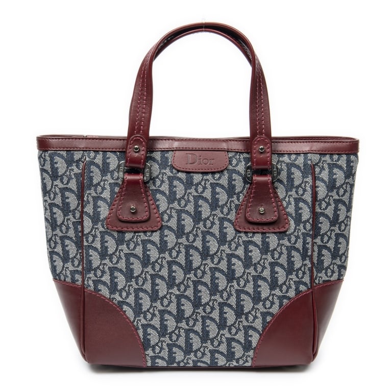 DIOR ZIP SHOPPING TOTE TRICOLOR BAG: The Dior Zip Shopping Tote features a sophisticated combination of red, navy, and grey Diorissimo canvas accented with sleek silver-tone hardware. Designed with a practical zip-top closure and spaciou