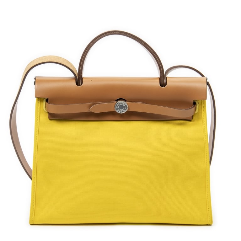 HERMES HERBAG ZIP PM YELLOW TOILE OFFICIER BAG: The Hermes Herbag Zip PM combines the timeless elegance of Hermes with practical everyday versatility. Crafted in vibrant yellow Toile Officier canvas and accented with palladium-plated hardware,