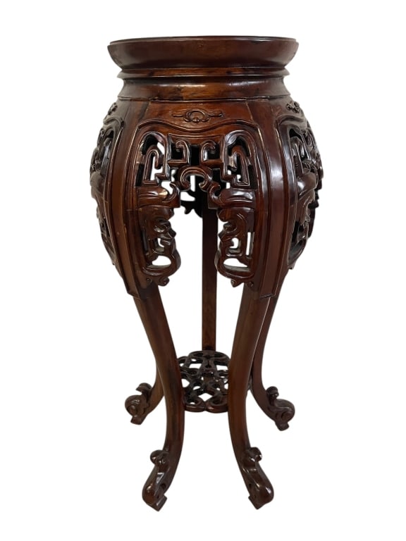 CARVED ASIAN HARDWOOD PEDESTAL PLANT STAND 34": Elegant carved Asian hardwood pedestal plant stand featuring a rich dark finish, rounded circular top, ornate pierced openwork apron, scrolling carved details, and gracefully curved cabriole-style