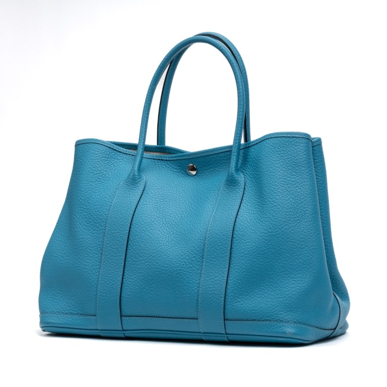 HERMES GARDEN PARTY 36 TURQUOISE BLUE BAG: The Hermes Garden Party 36 is a timeless luxury tote crafted in vibrant turquoise blue Fjord leather and designed with the understated elegance that defines the house of Hermes. Renowned for its spaci