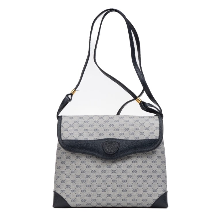 GUCCI VINTAGE NAVY IVORY SUPREME BAG: The Gucci Vintage Shoulder Flap Bag is crafted in classic navy blue and ivory Micro Supreme coated canvas, showcasing the timeless elegance of Gucci's heritage designs. Featuring a refined flap-front 