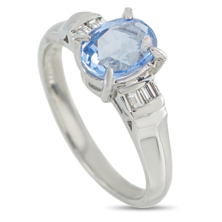 PLATINUM 0.11CT DIAMOND AND SAPPHIRE RING MF07-110: In this platinum ring, a 1.66-carat sky-blue oval sapphire commands attention with serene confidence. Its high setting allows the gem to glow freely. Flanked by east-west baguette diamonds in a precis