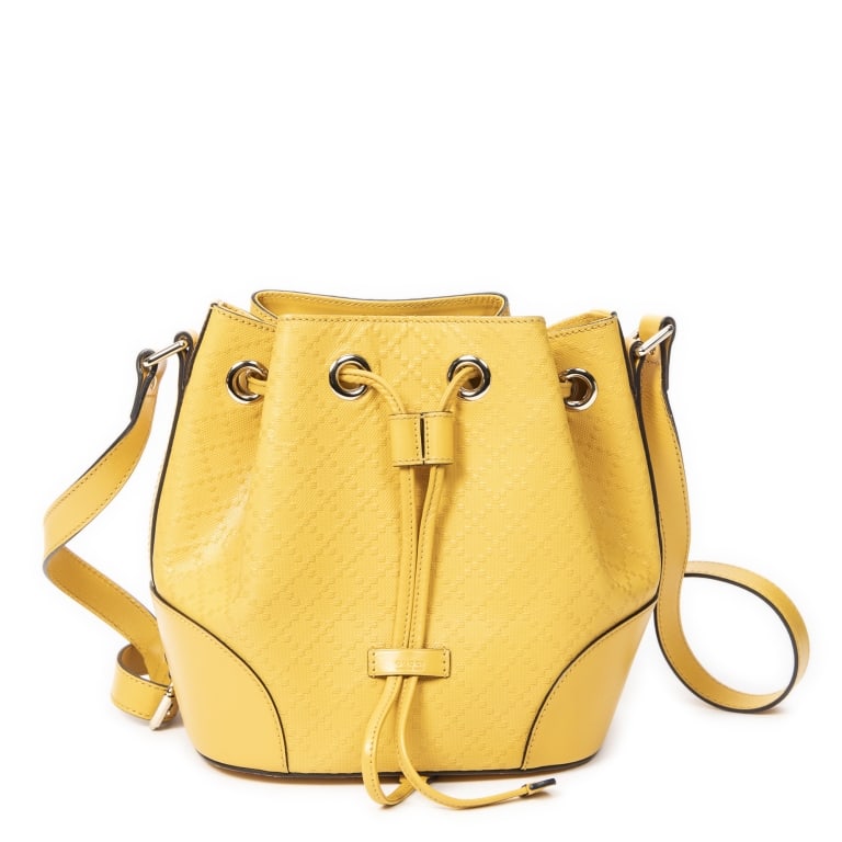 GUCCI DIAMANTE DRAWSTRING BUCKET BAG: The Gucci Drawstring Bucket Bag is crafted in vibrant yellow Diamante embossed calfskin leather, showcasing one of Gucci's signature geometric patterns. Featuring a timeless bucket silhouette with a s