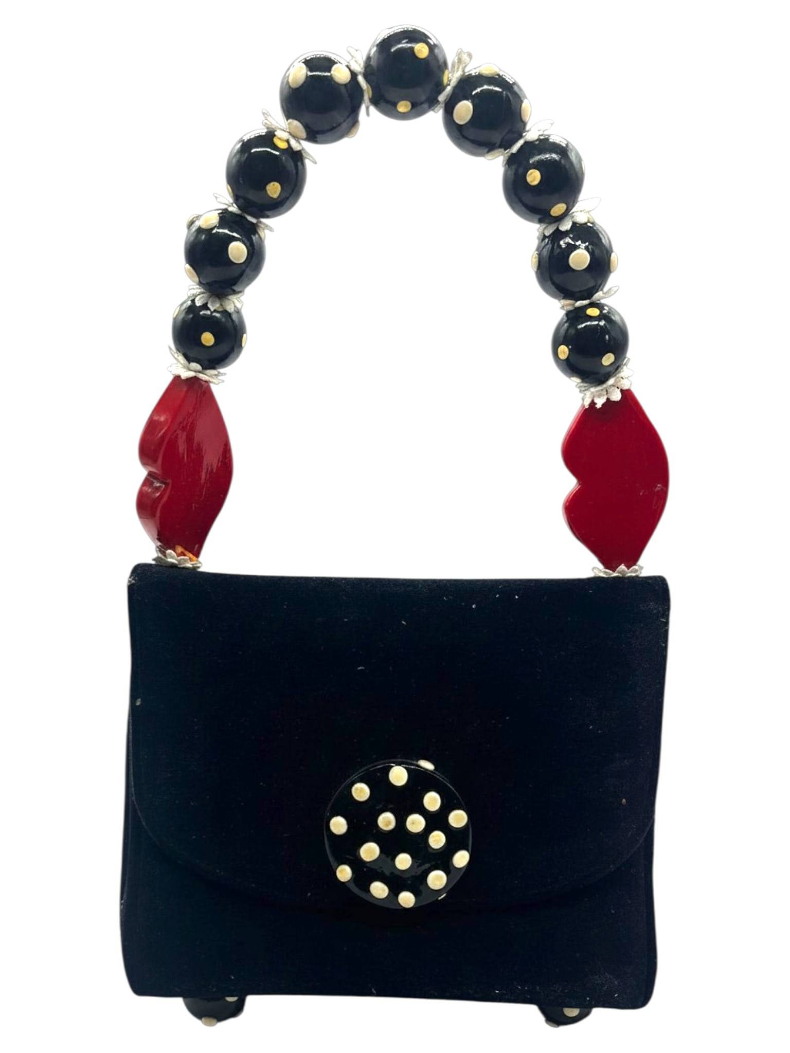 RITA COLOMBO BLACK VELVET KISS & POLKA DOT BAG 16": Playful Rita Colombo handbag in black velvet with a distinctive handle featuring black and white beads and red lip-shaped accents. The interior is lined with a red lips print fabric. Button closure wi