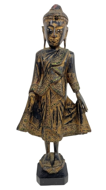 BURMESE STYLE GILTWOOD BUDDHA FIGURE 22": Decorative standing Buddha figure crafted in the Burmese or Southeast Asian taste, featuring a distressed gilt and black finish with applied colored glass jewel embellishments throughout the robe and 