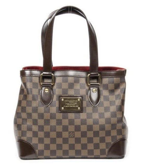 LOUIS VUITTON HAMPSTEAD PM CANVAS SHOULDER BAG: The Louis Vuitton Hampstead PM exudes everyday elegance with its structured silhouette crafted from durable Damier Ebene coated canvas. Accented by golden brass hardware, rich brown leather trim, and 