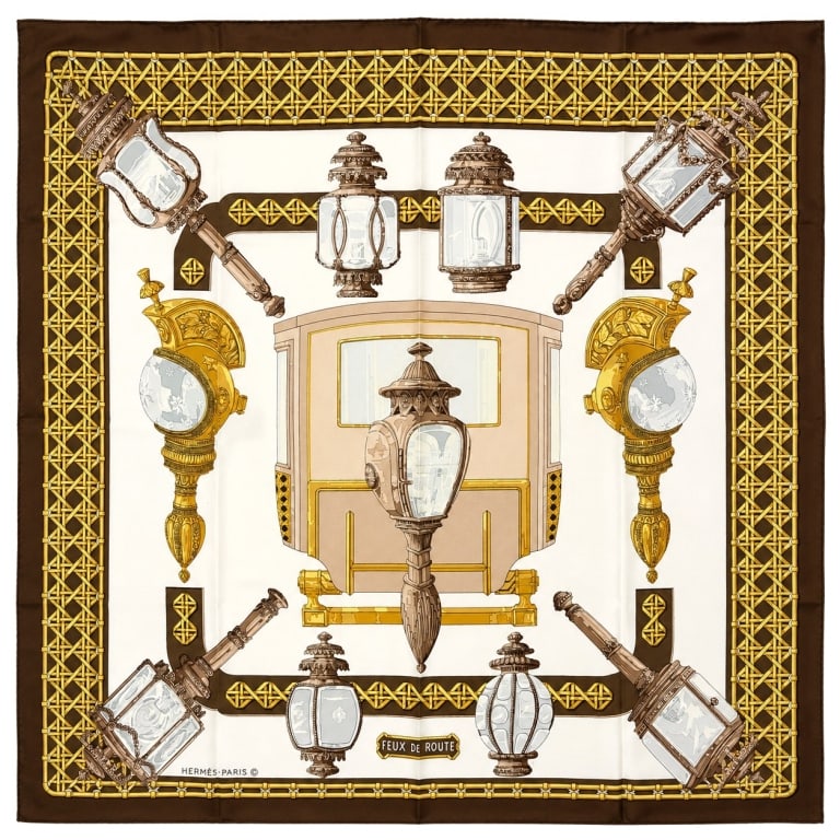 HERMES FEUX DE ROUTE SILK SCARF 35": A sophisticated Hermes Paris silk scarf featuring the sought-after Feux de Route design, showcasing an elegant arrangement of antique carriage lanterns and street lamps rendered in rich shades of gold