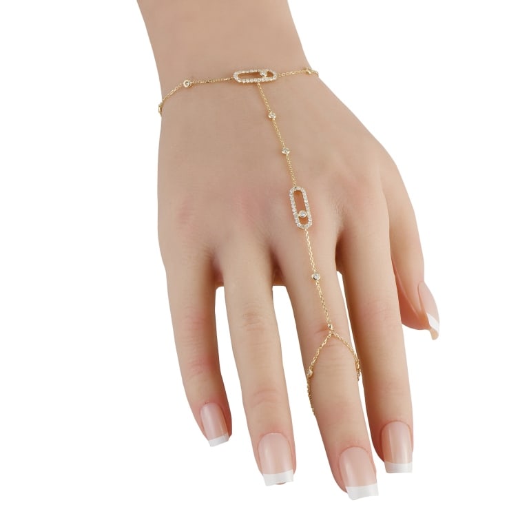 14K YELLOW GOLD 0.80CT DIAMOND HAND CHAIN BRACELET: An LB Exclusive piece designed with a seamless fusion of a ring and a bracelet. This piece features a delicate 14K yellow gold chain that drapes elegantly across the back of the hand. Petite round dia