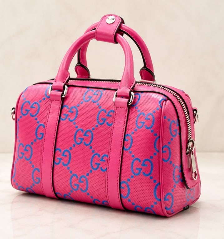 GUCCI GG EMBOSSED MINI DUFFLE TOP HANDLE BAG 10": A striking Gucci GG Embossed Mini Top Handle Duffle Bag crafted in vibrant fuchsia pink perforated leather with oversized blue GG monogram detailing throughout. This bold contemporary design showcases