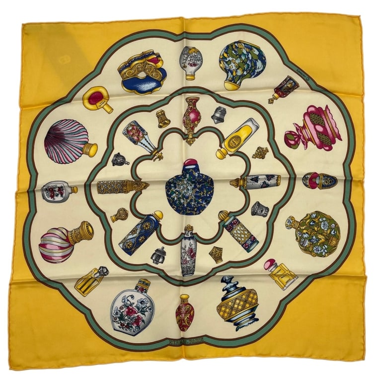 HERMES PARIS SNUFF SILK POCKET SQUARE 16": This authentic Hermes Paris silk pocket square features a vibrant yellow border surrounding an elegant arrangement of decorative bottles and vanity accessories rendered in the maison?s distinctive lux