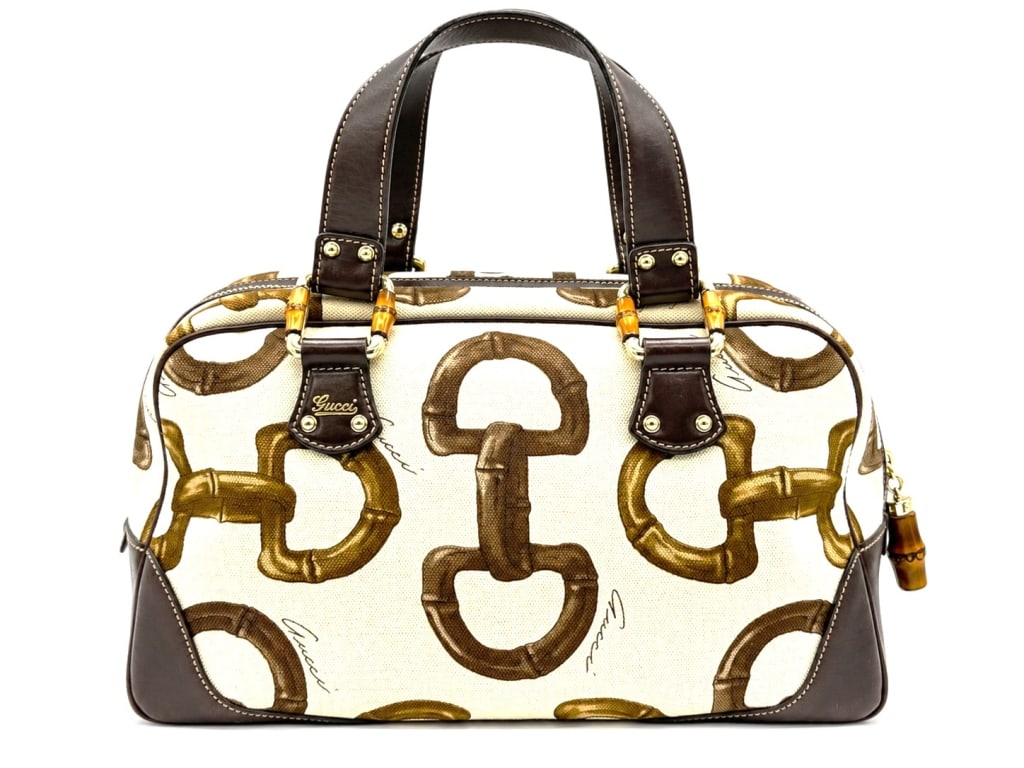 GUCCI HORSEBIT CANVAS BAMBOO BOSTON BAG 16": This Gucci Horsebit Boston bag features a beige canvas body adorned with an oversized brown horsebit and bamboo print, complemented by rich brown leather trim and dual leather top handles. Signature b