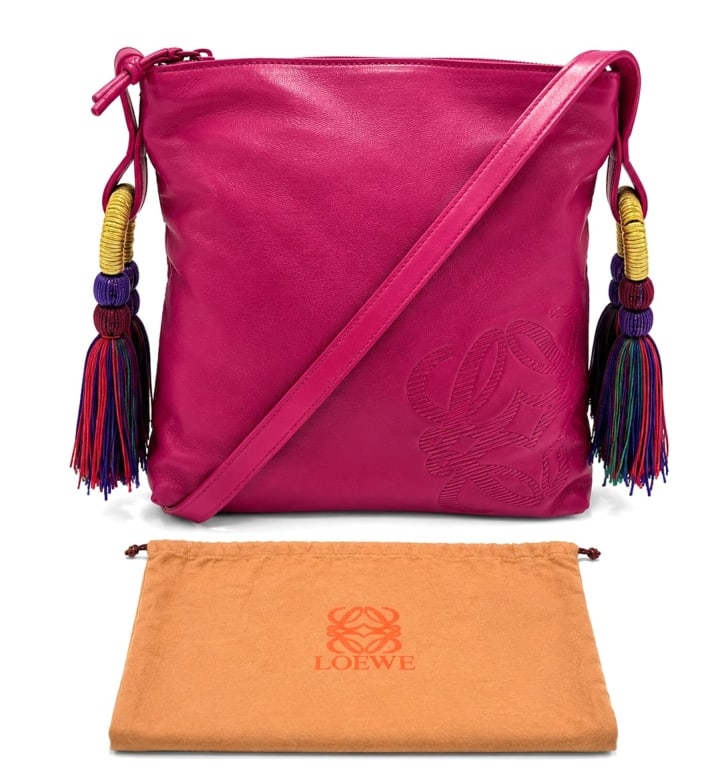 LOEWE PINK LEATHER TASSEL SHOULDER BAG 10": Loewe pink soft leather shoulder bag featuring the iconic embossed Anagram logo at the lower corner and decorative multicolor tassel accents suspended from gold-tone wrapped rings at each side. Crafte
